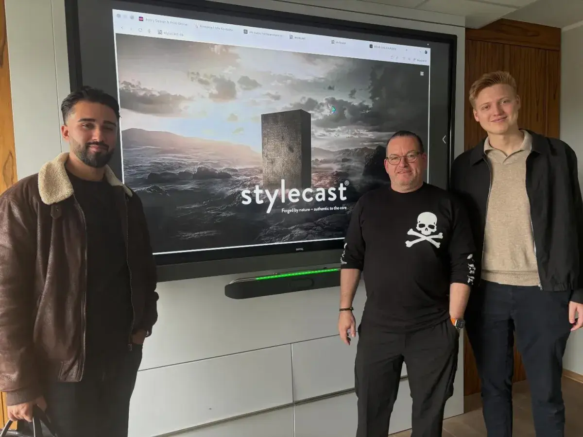 Übergabe der neuen Stylecast-Website, drei Personen vor einem großen Bildschirm
