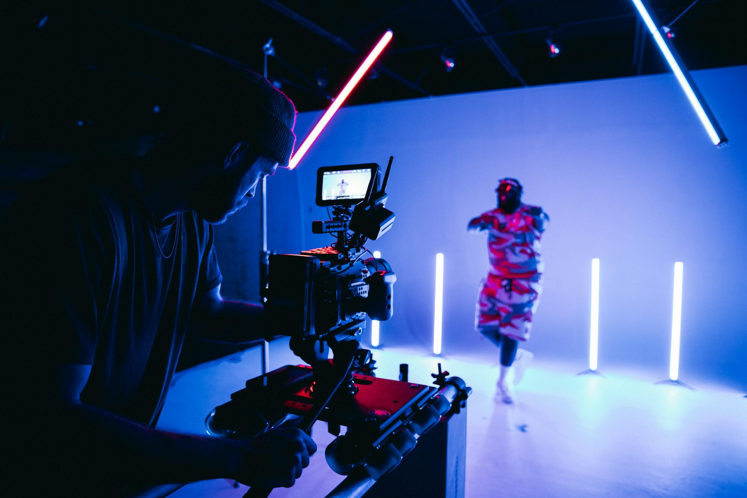 Kameramann filmt eine Tänzerin in einem blau beleuchteten Studio
